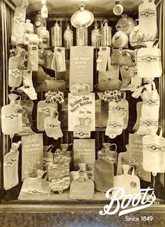 Black and white window display from a Boots shopfront featuring hot water bottles