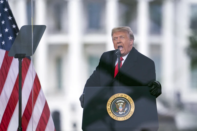 A man stands at a lectern, speaking.