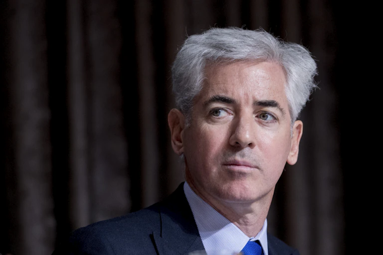 Well-dressed man with gray hair looks over his shoulder.
