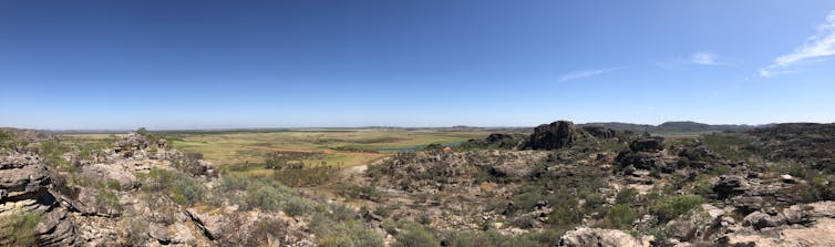 A panorama of a rocky landscape with a blue sky above it