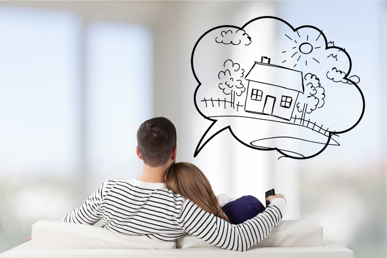 Couple sitting on sofa (from behind), with speech bubble with house drawn inside it.
