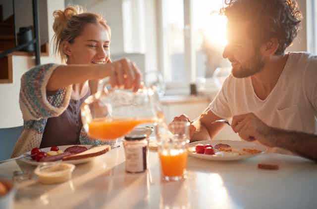 Photo d’un jeune couple en train de prendre son petit déjeuner.