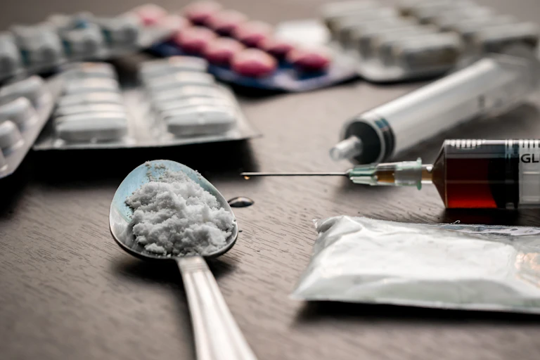 Drug syringe and cooked heroin on spoon
