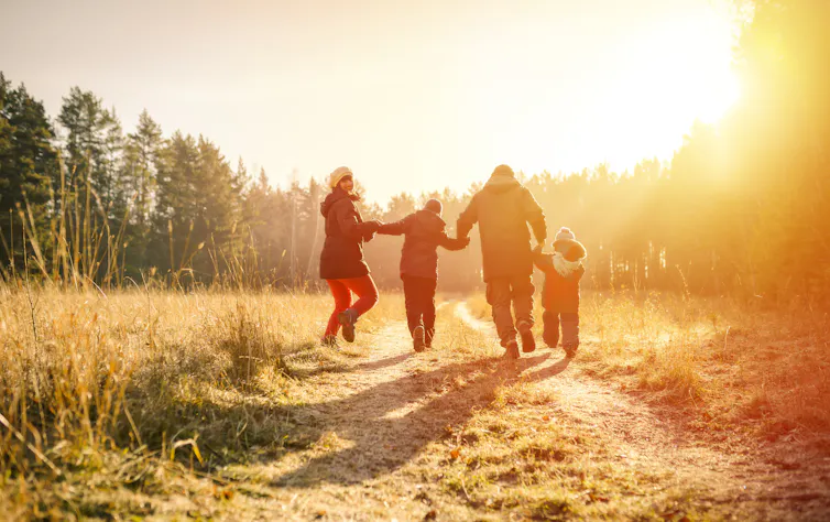 A family walks outdoors in the winter.