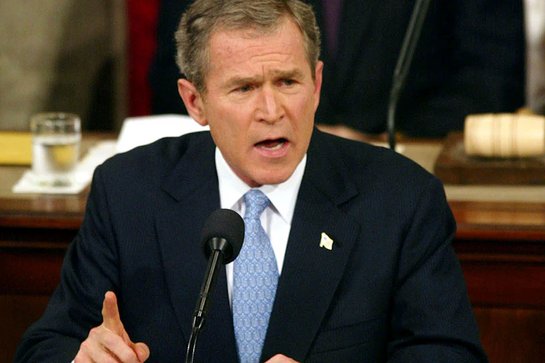 Former president George W Bush at a microphone.