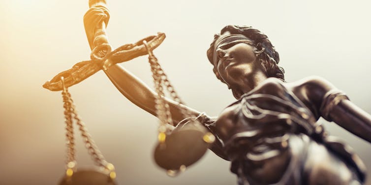 Close up photo of a statue of Justice, holding the scales of justice