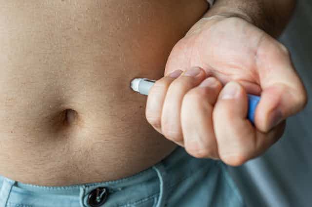 A man injects his belly with the weigh-loss jab