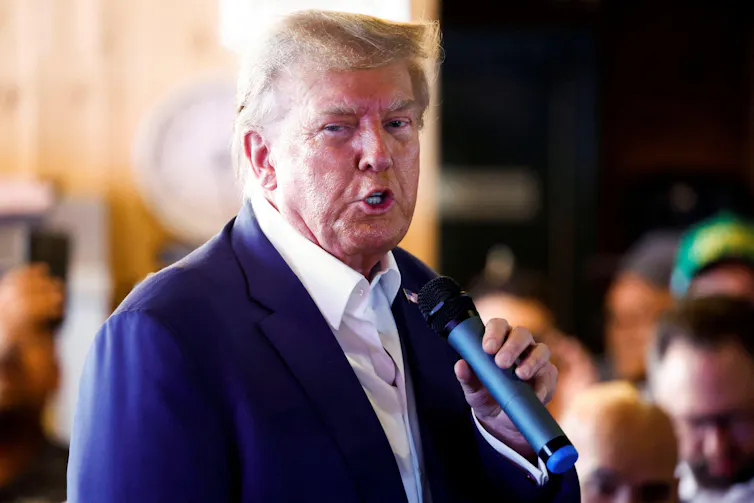 Donald Trump looking at the camera, wearing a blue jacket.