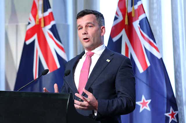 ACT Party leader David Seymour speaking in front of NZ flag