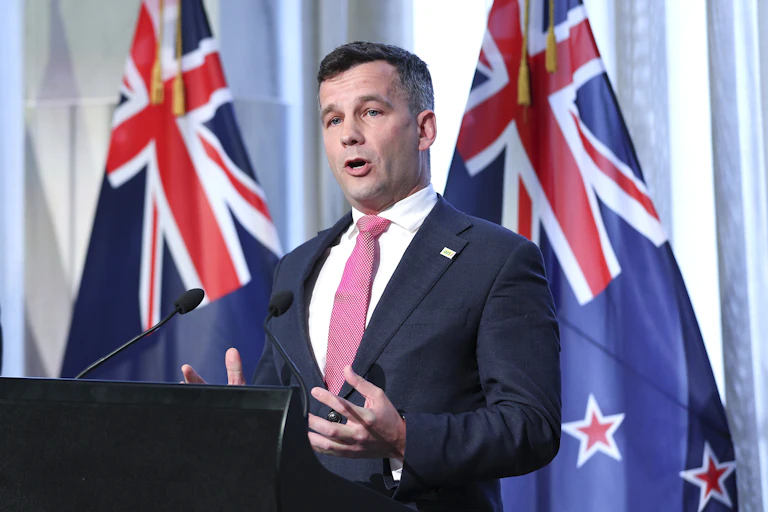 ACT Party leader David Seymour speaking in front of NZ flag