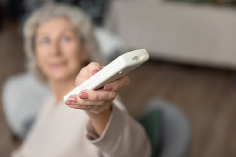 Woman turning aircon on