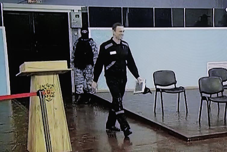 Russian dissident leader Alexei Navalny, walks into a Russian courtroom.
