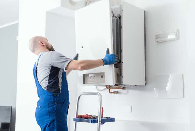 An engineer doing a boiler inspection at a home.