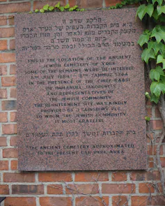 A commemorative plaque on a brick wall.