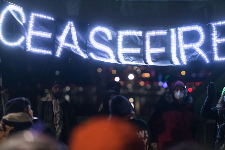 Protesters hold a banner saying: ceasefire.