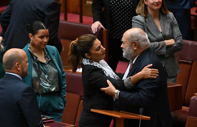 Senator Lidia Thorpe and Senator Patrick Dodson embrace in parliament house.