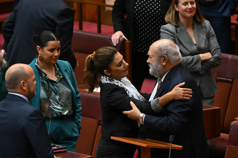 Senator Lidia Thorpe and Senator Patrick Dodson embrace in parliament house.