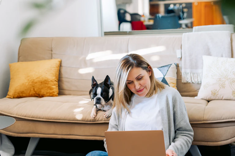 A woman sitting on the floor using a laptop.