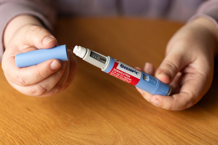 A person holds a vial of Ozempic.