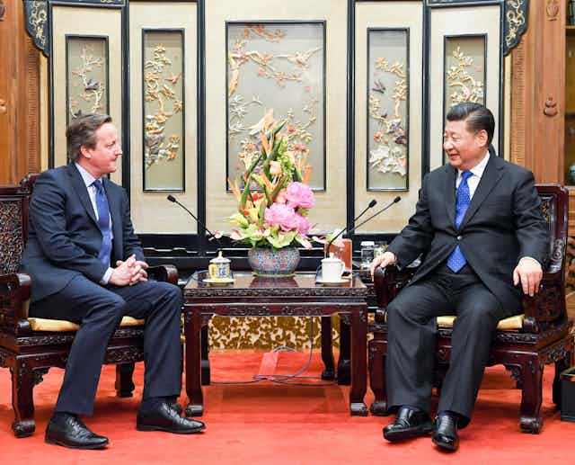 David Cameron sitting with Xi Jinping.