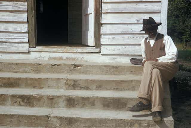 A man included in the Tuskegee syphilis study sits on steps in front of of a house in Tuskegee, Alabama.