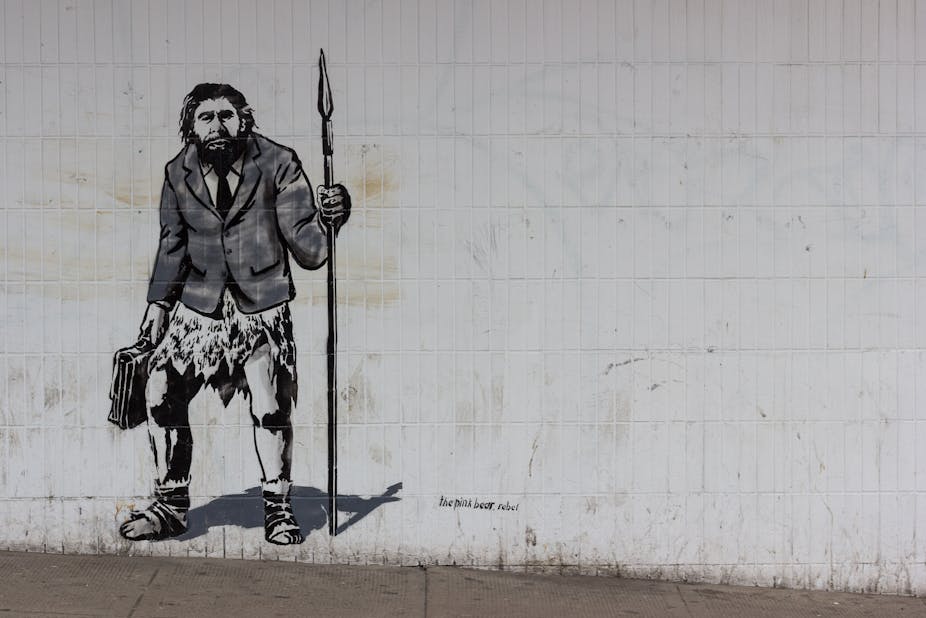 Graffiti représentant un homme préhistorique en costume de ville.