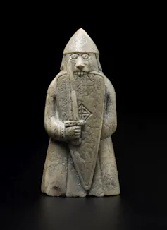 Uma peça de xadrez representando um berserker mordendo seu escudo.