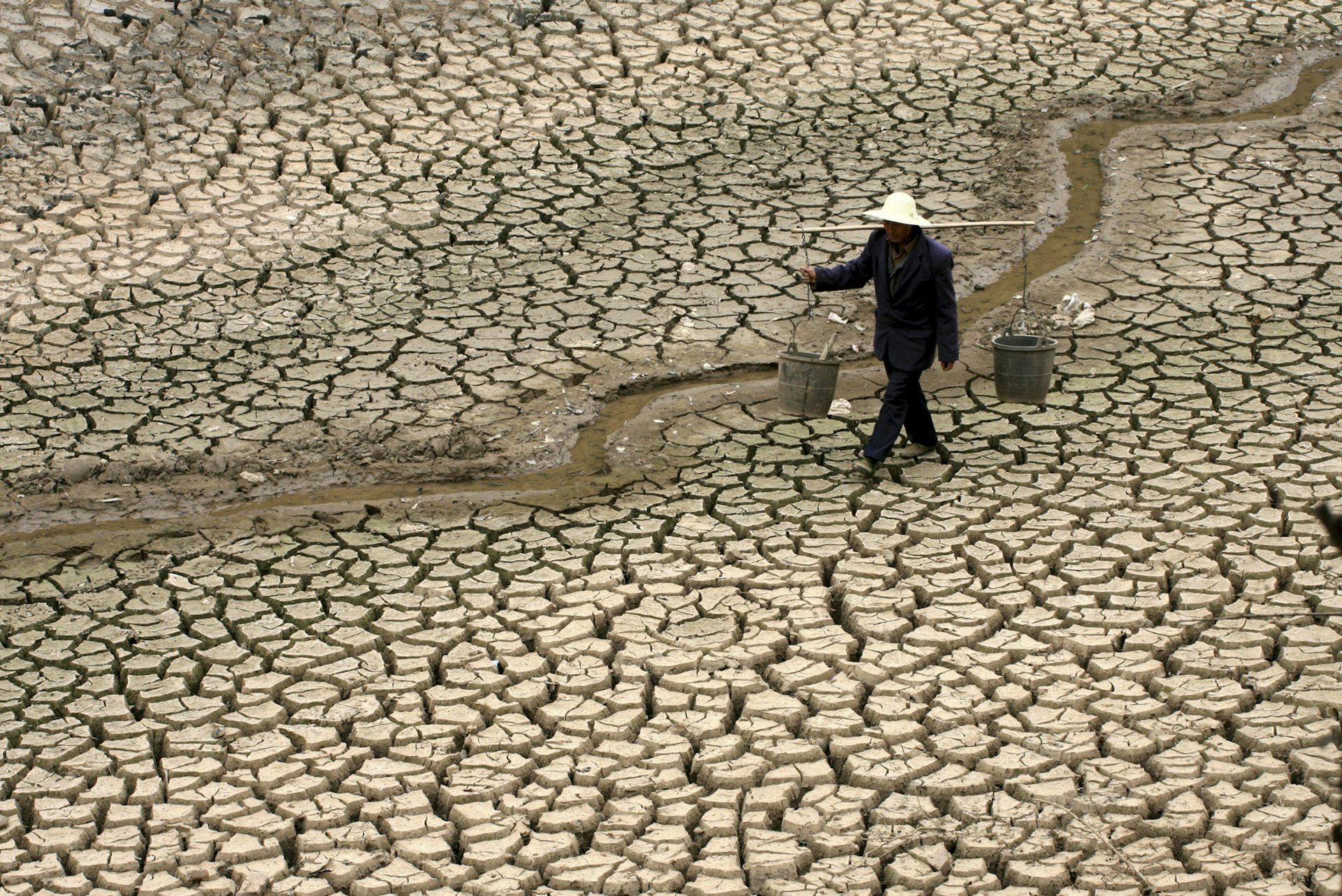 A Chinese farmer walks on a dry river bed looking for water during an extreme drought in Yunnan province in 2010.