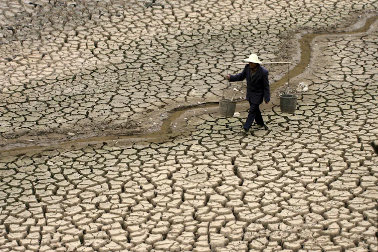 A Chinese farmer walks on a dry river bed looking for water during an extreme drought in Yunnan province in 2010.