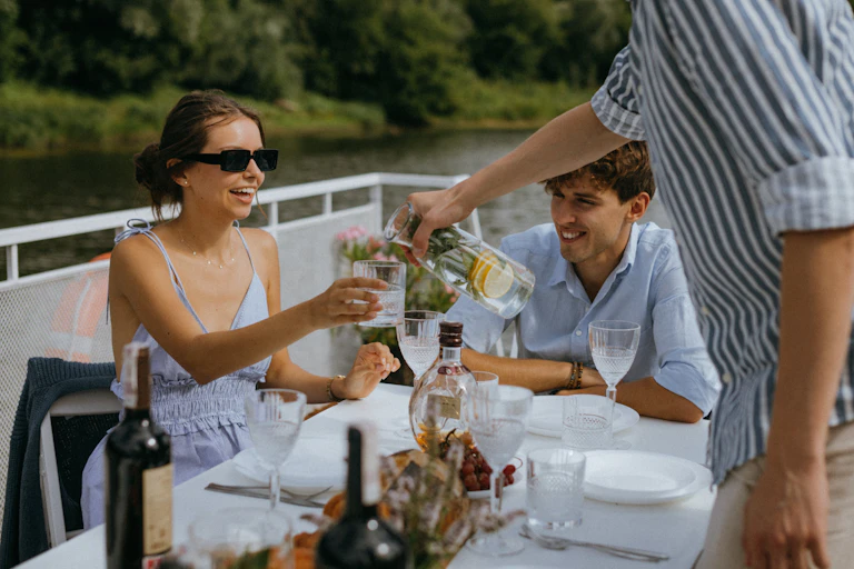 Un homme et une femme déjeunant sur un bateau.