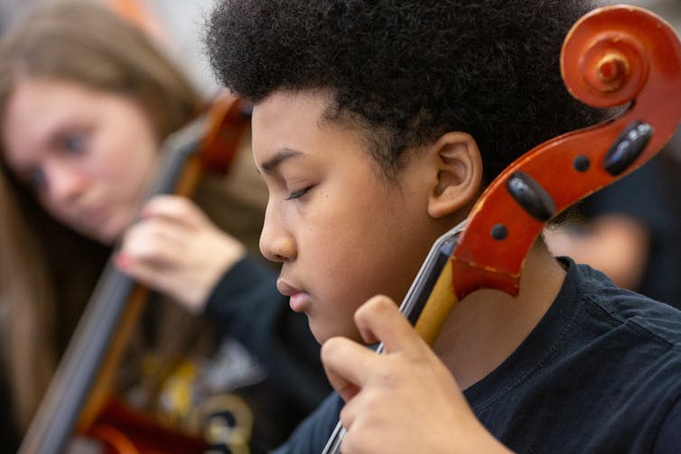 A pre-teen child playing a stringed instrument.