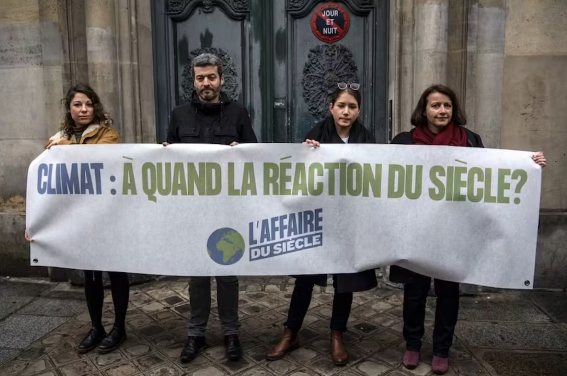 4 personnes tiennent une pancarte sur laquelle est écrit climat à quand la réaction du siècle