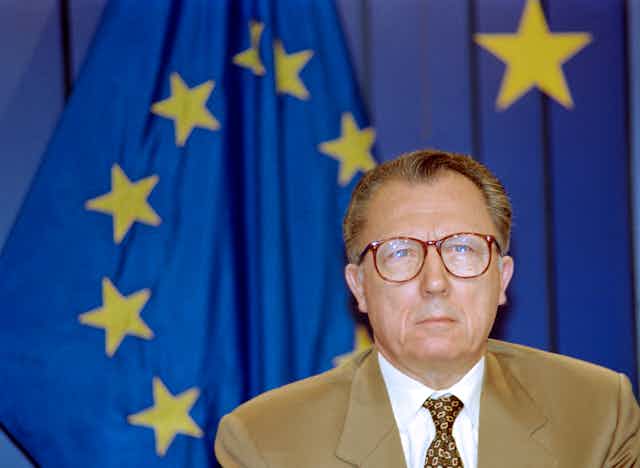 Jacques Delors devant un drapeau de l'UE
