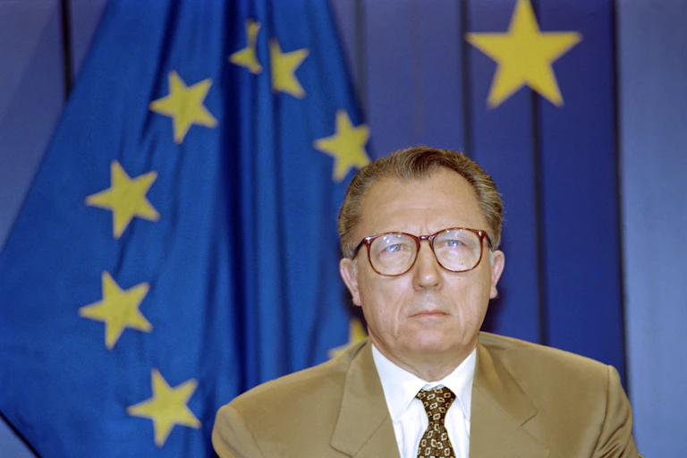 Jacques Delors devant un drapeau de l'UE