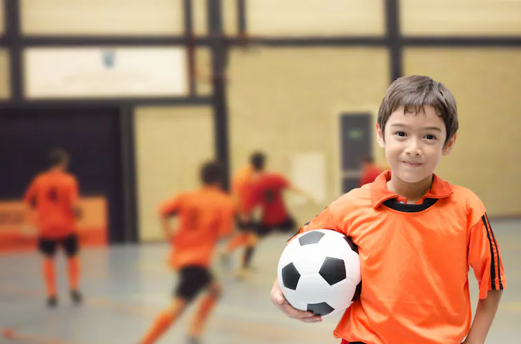 A young child holding a soccer ball.