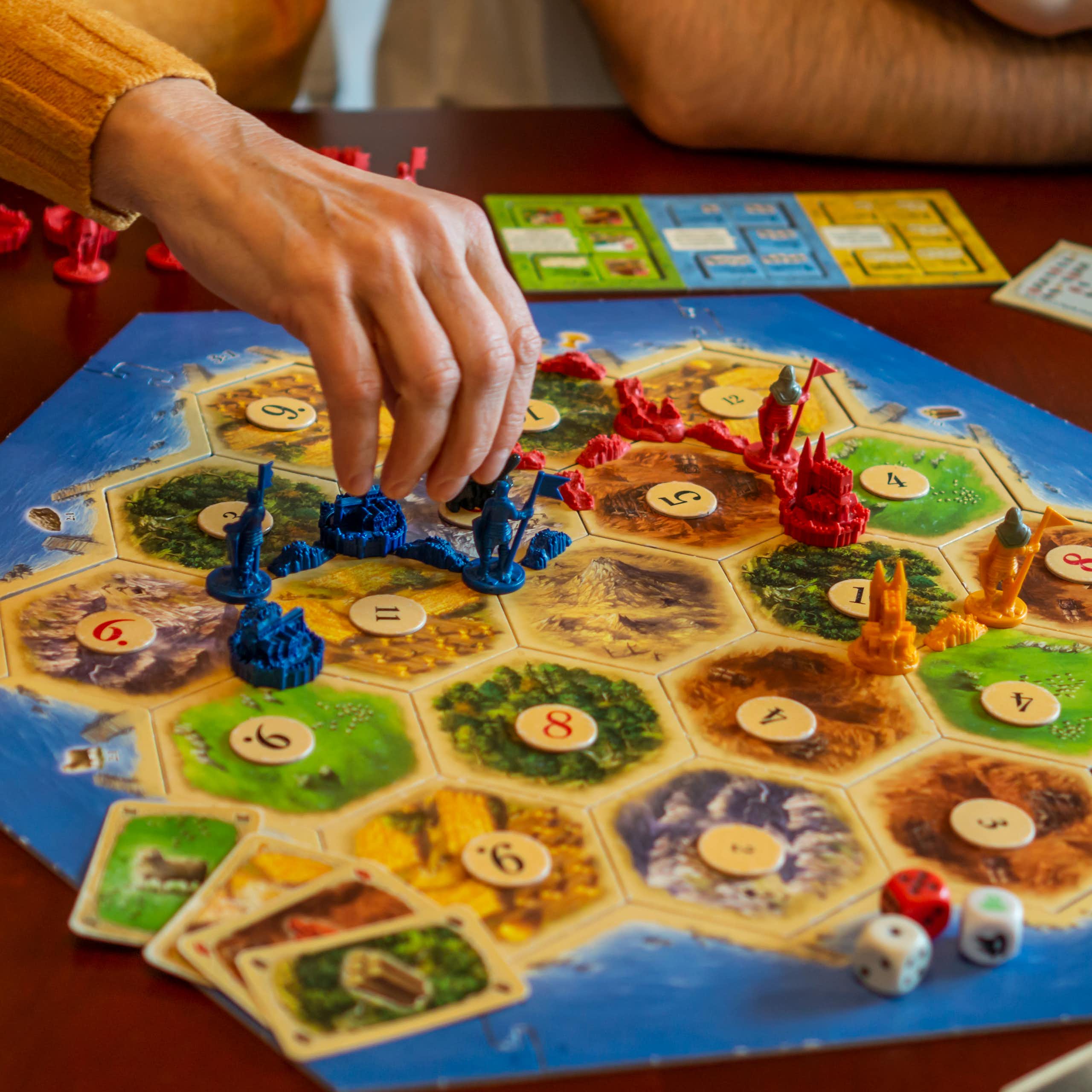 People playing the board game version of Catan.