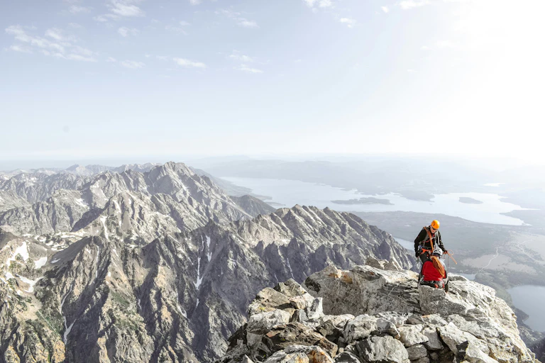 A mountainous landscape with two climbers.