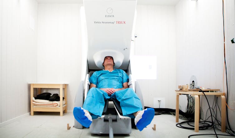 Patient seated while having his brain activity scanned in a research centre.