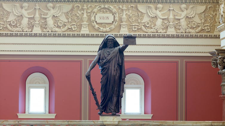 A statue of a bearded man holding a scroll.