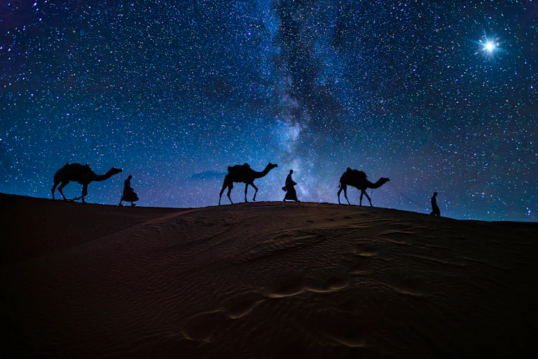 Ilustração mostra três homens e seus camelos atravessando deserto à noite seguindo uma estrela brilhante