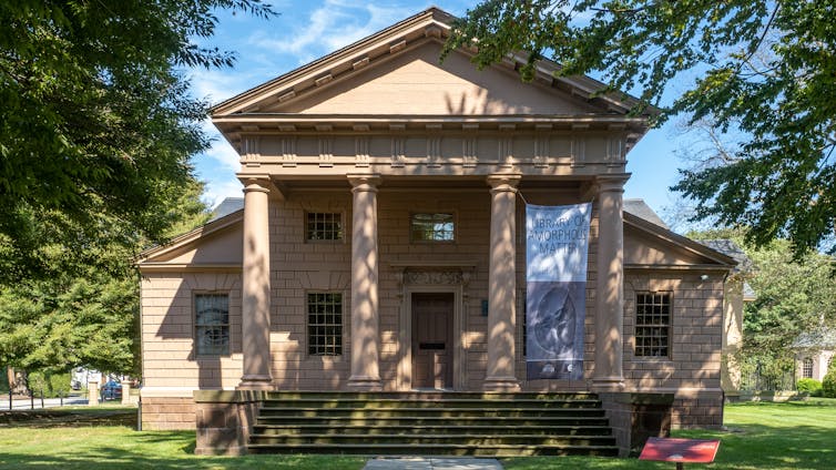 The facade of a building, with four columns supporting a portico.