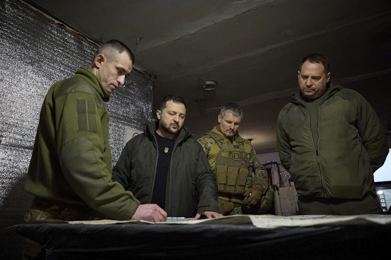 Ukrainian president Volodymyr Zelensky with aides looking at charts in a military bunker.