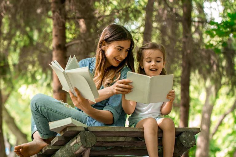 Jeune mère et fille lisant un livre dans les bois