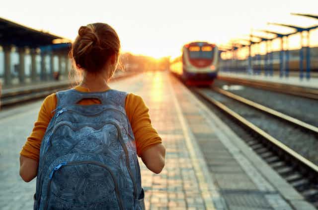 Jeune femme avec un sac à dos sur le quai d'une gare