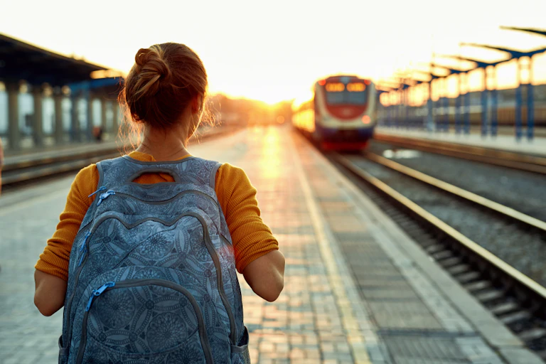 Jeune femme avec un sac à dos sur le quai d'une gare