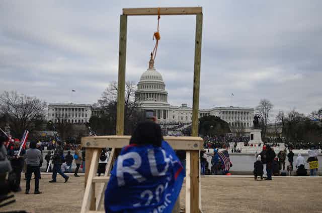a makeshift scaffold with noose with the US Capitol building in the background