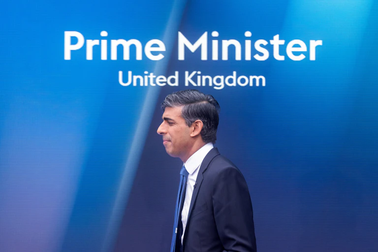 Rishi Sunak walking under a sign that reads Prime Minister, United Kingdom