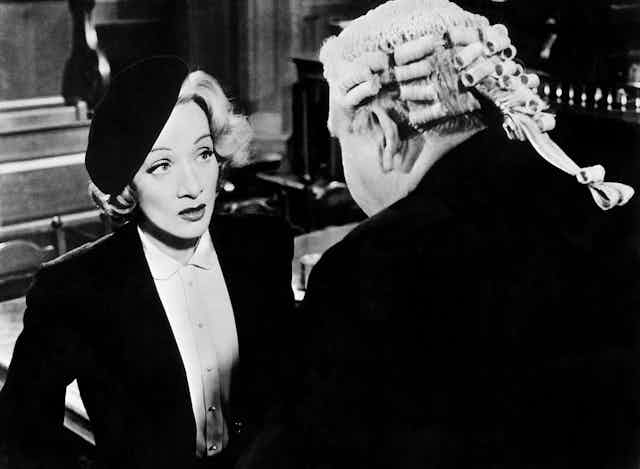 Black and white photo of a well dressed woman and man in courtroom wig