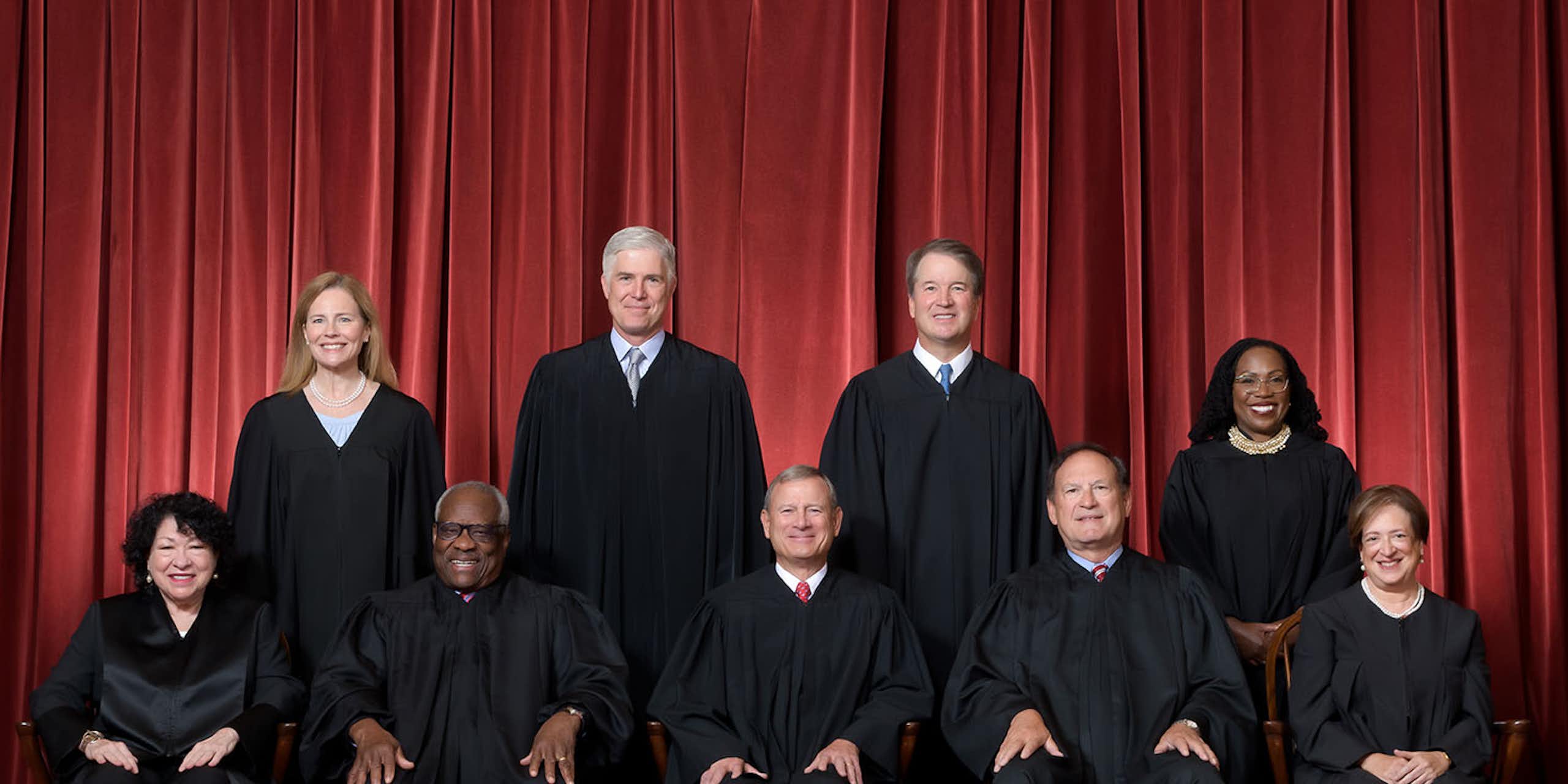 Les neuf juges de la Cour suprême des États-Unis prennent la pose en tenue officielle devant un rideau rouge