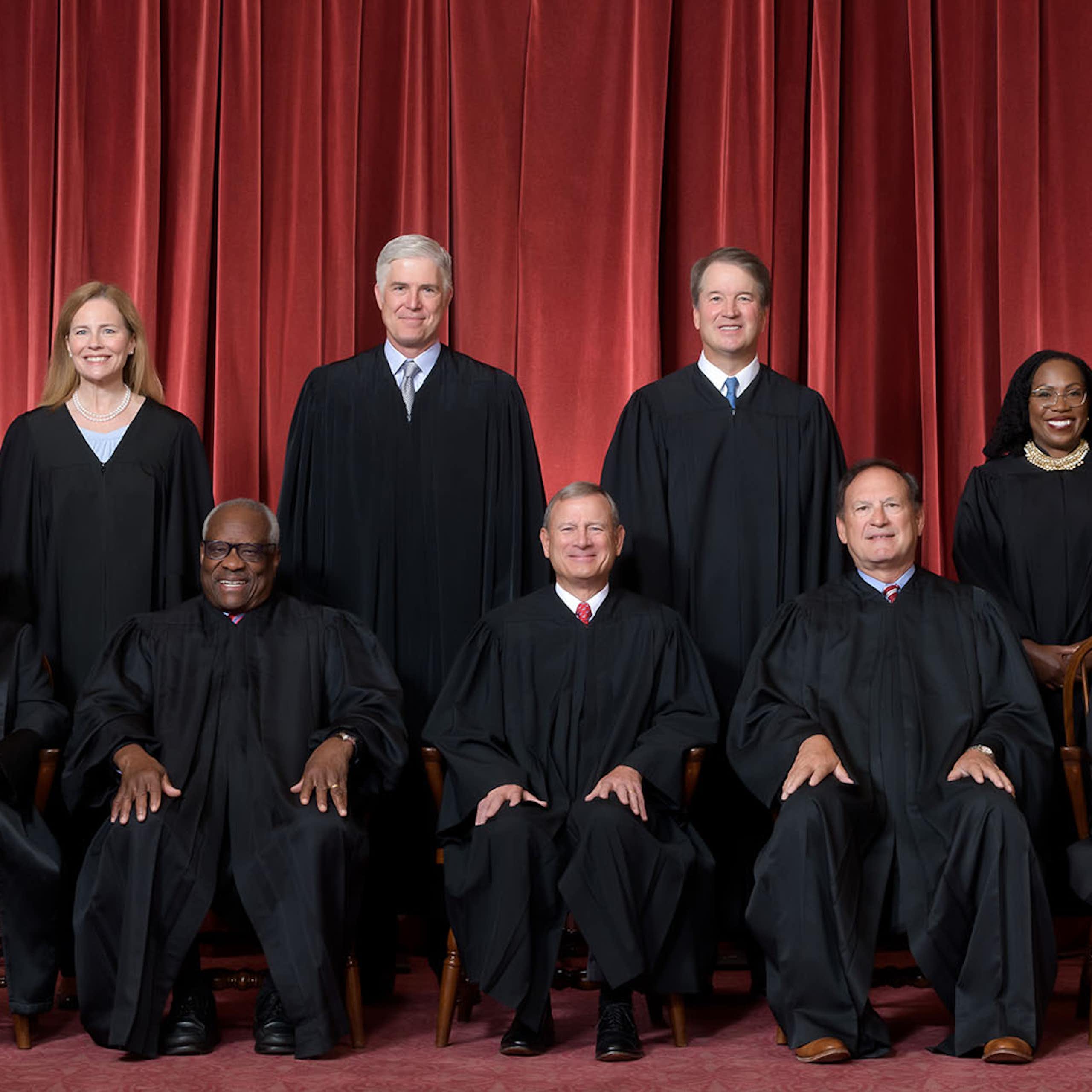 Les neuf juges de la Cour suprême des États-Unis prennent la pose en tenue officielle devant un rideau rouge
